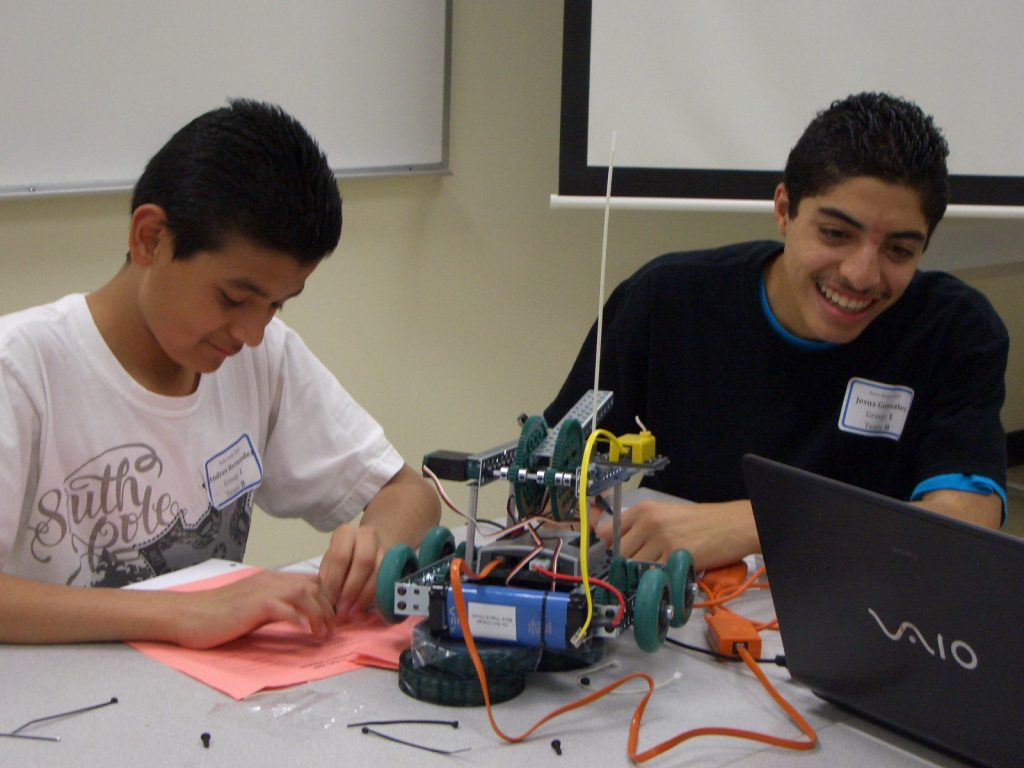 Due studenti alle prese con un robot