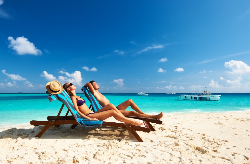 Due persone su una spiaggia intente ad abbronzarsi