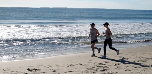 Due persone che fanno jogging sulla spiaggia