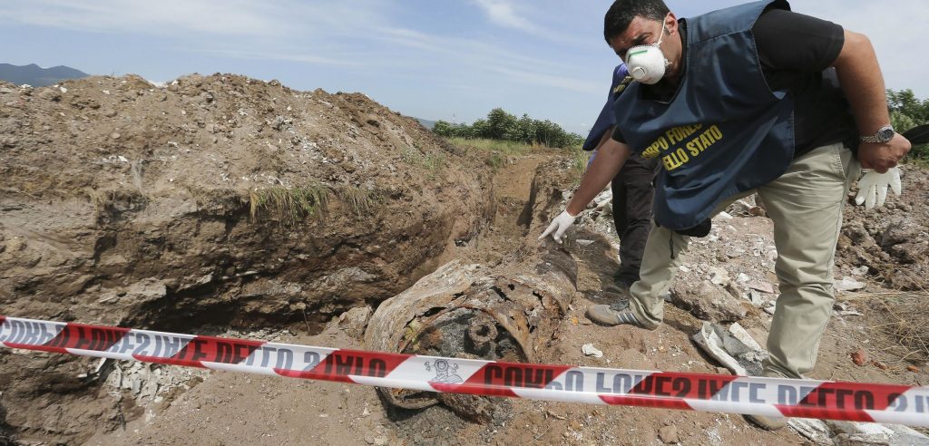 Un agente del Corpo Forestale dello Stato indica una discarica abusiva (foto: http://napoli.fanpage.it/)