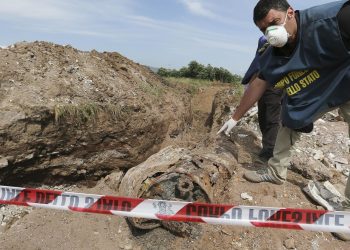 Un agente del Corpo Forestale dello Stato indica una discarica abusiva (foto: http://napoli.fanpage.it/)