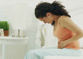 Una donna si tiene il ventre dolorante (foto: www.bolsademulher.com)
