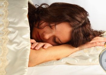 Una ragazza dorme accanto a una sveglia (foto: www.fitness4lifebrasil.com)