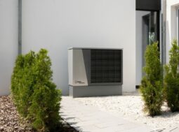 Unità esterna di una pompa di calore sulla parete di una casa, tra le tecnologie finanziabili con la clausola energetica UE