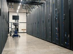 Corridoio di rack in un data center: l'infrastruttura che sostiene l'intelligenza artificiale