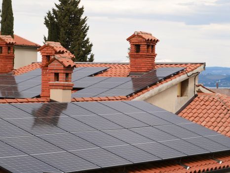 Pannelli solari e fotovoltaici su tetti in tegole di un quartiere residenziale