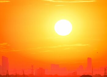 Il giorno più caldo di sempre: lo skyline di una città controluce sotto un cielo arancione
