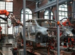Analisi del ciclo di vita (LCA): carrozzeria di un'auto in fabbrica tra i bracci robotici