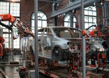 Analisi del ciclo di vita (LCA): carrozzeria di un'auto in fabbrica tra i bracci robotici